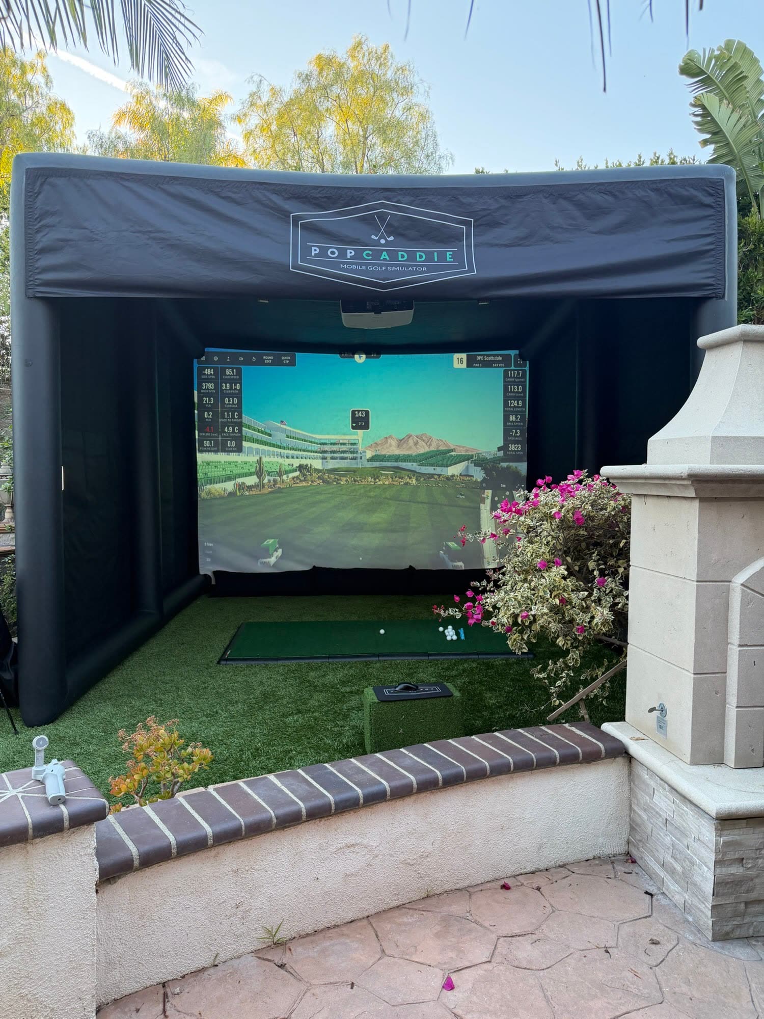 Simulador de golf hinchable montado en el jardín de una casa (evento de PopCaddie)